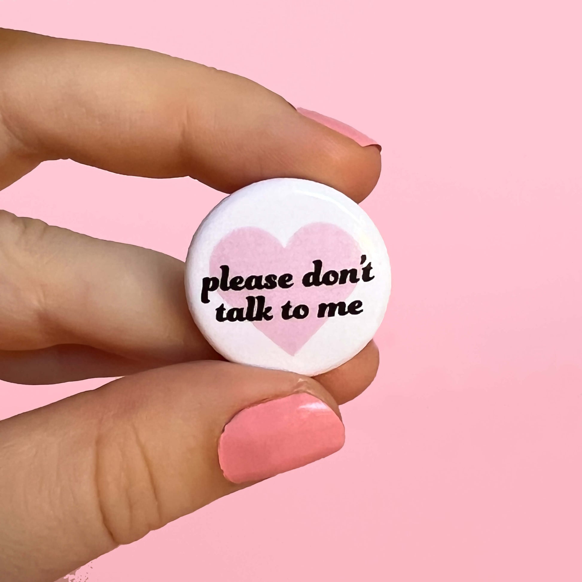 white and pink button "please don't talk to me"